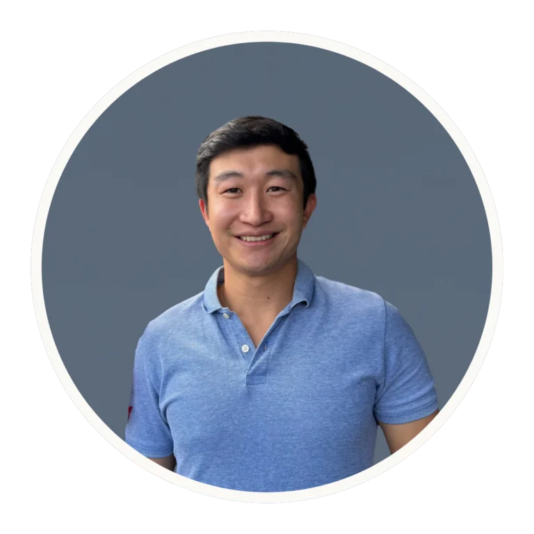 Dr. Tony Chan smiles in a blue polo shirt against a slate-blue background.